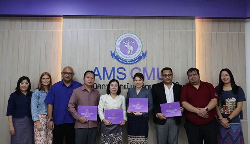 Participants in the closing ceremony gathered in a University classroom, posing in front of the University logo. Trainees hold their diplomas in their hands.